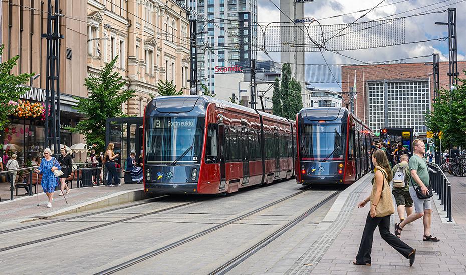 Kaksi ratikkaa Hämeenkadun ratikkapysäkeillä. 