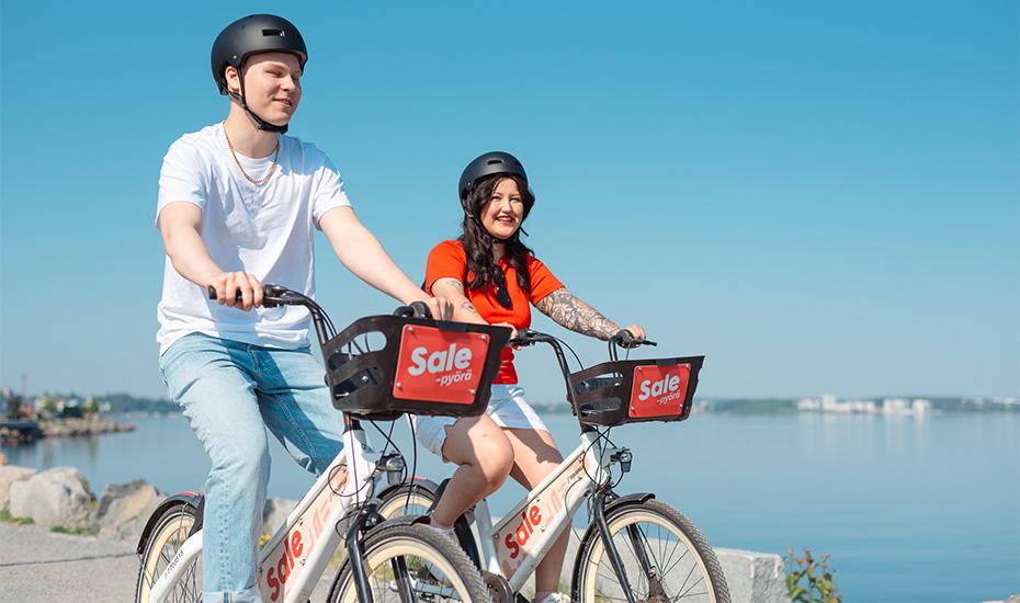 A man and a woman riding city bikes in Ranta-Tampella. 
