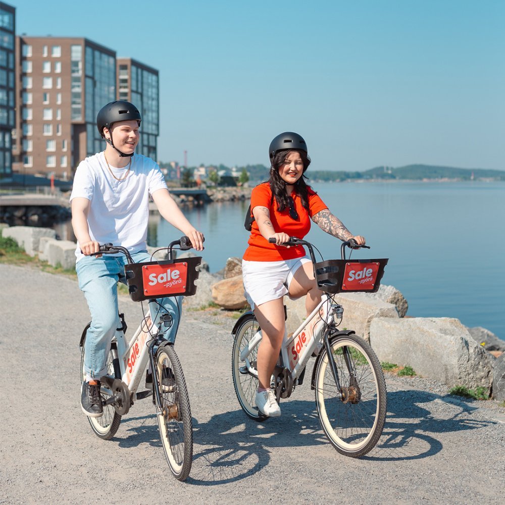 A man and a woman riding city bikes in Ranta-Tampella. 