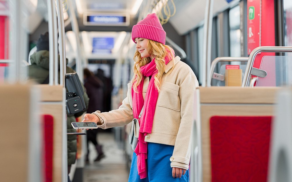 The woman pays for her journey in the tram with a mobile ticket. 